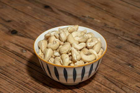 Dried cashew nuts in containers on wooden countertopsの写真素材