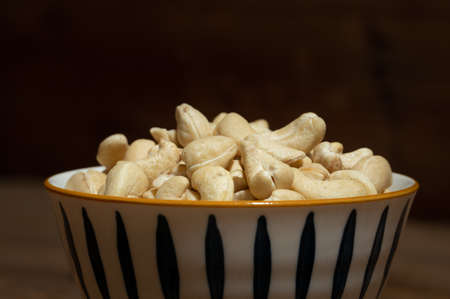 Dried cashew nuts in containers on wooden countertopsの写真素材