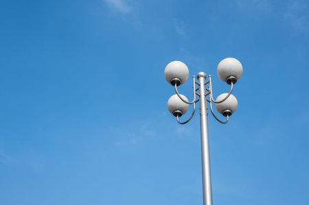 A street lamp composed of four round bulbs under the blue sky
