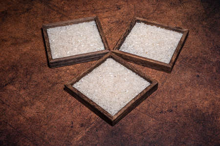 Some square containers of white rice in the dark backgroundの写真素材
