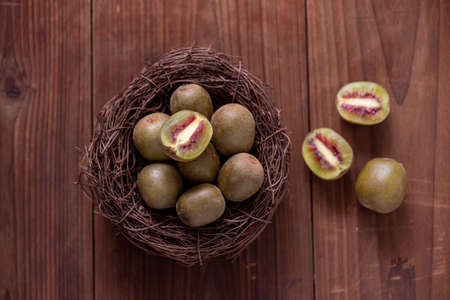 The cut kiwi fruit is placed on a plate on a wooden tableの写真素材