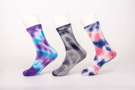 Three pairs of socks of different colors and styles are sleeved on the foot mold on a white backgroundの写真素材
