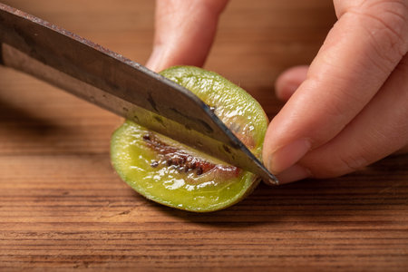 Cut ripe kiwi fruit on a wooden table.
