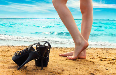 Girls stands on a beach barefootedの写真素材