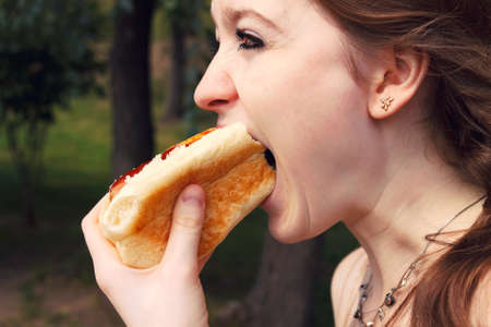 girl eatign hotdog on hikeの写真素材