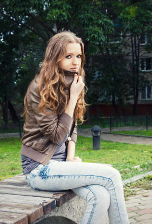 Young lady freezes on a bench in a parkの写真素材