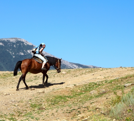 Girl on a hourse in the mountainsの写真素材