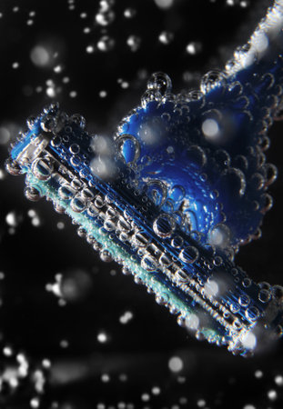 Razor blade close up in cold soda water with bubbles on black backgroundの写真素材