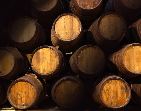 Row of wooden barrels of tawny portwine (port wine) in cellar, Porto, Portugal. Vintage old style