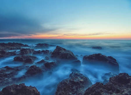 Seascape with sunset and rocks in a calm sea water. Soft focus Natural landscapeの写真素材