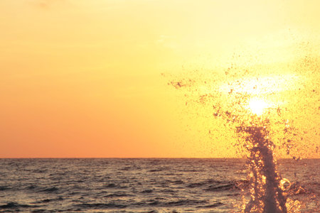 splash of sea wave at sunset. Counter light. Travel and business abstract backgroundの写真素材