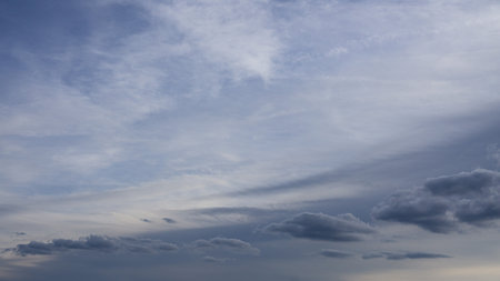 Multiple cloud sweep layers across the scene, shifting from bright whites to deep grays. Subtle...
