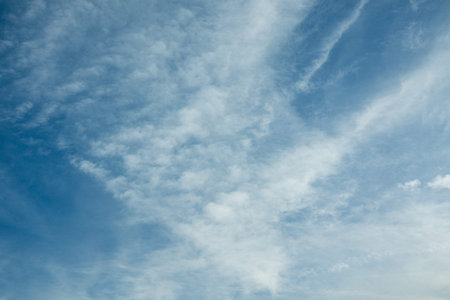 Feathered cloud patterns form a gentle texture across the frame. The open composition leaves...