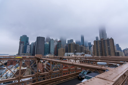 New York, US - March 29, 2018: Downtown Manhattan with buildings obsucured under heavy fog as seen from Brooklyn bridgeのeditorial素材