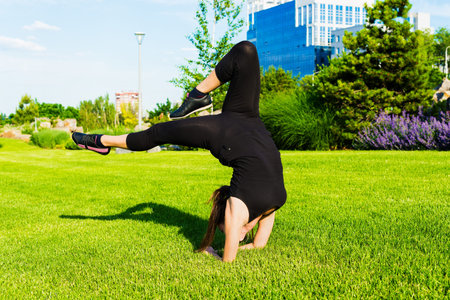 The young beautiful girl doing gymnastics outdoors