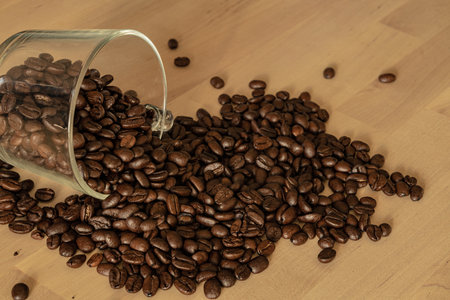 Glass of coffee beans on a wooden tableの写真素材
