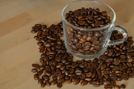 Spilled coffee beans on a wooden backgroundの写真素材
