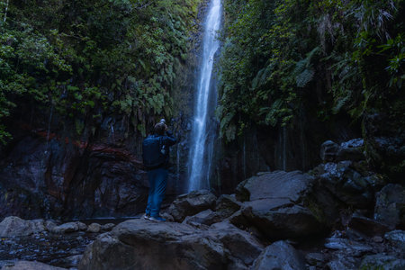 Lagoa das 25 Fontes. Tourist taking photo of waterfall. Madeira, Portugalの写真素材