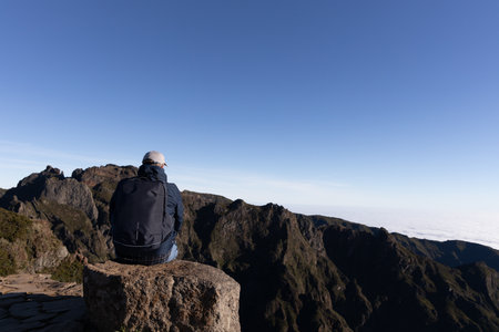 Tourist sits at mountain top against the background of majestic mountains, Madeira, Portugalの写真素材