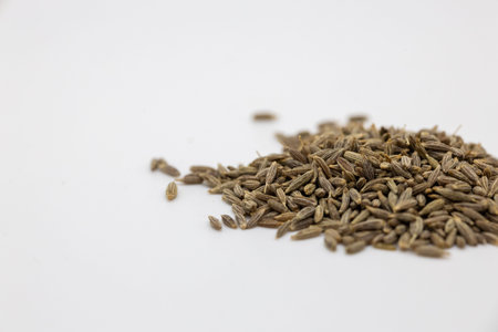 a pile of Cumin seed that is sitting on a white surface