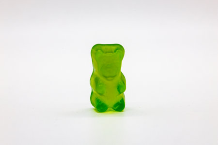 Single Green Gummy Bear Candy on White Backgroundの写真素材
