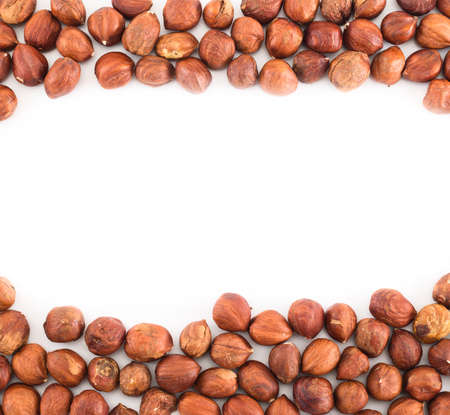 Hazelnuts over white surface as a frame copyspace empty backgroundの写真素材