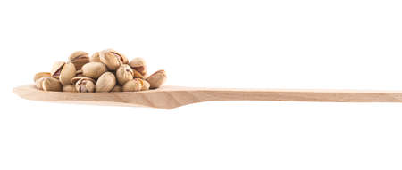 Wooden spoon full of pistachio isolated over white background, side viewの写真素材