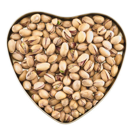 Heart shaped box full of pistachio nuts isolated over white background, top viewの写真素材