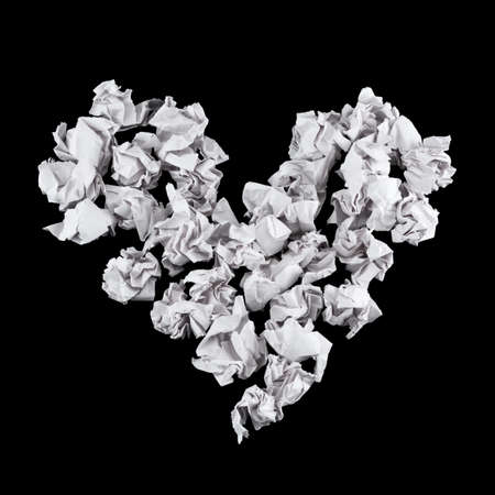 Heart shape made of crumpled paper balls over black backgroundの写真素材