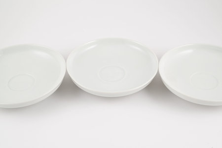 White ceramic plate dishes over white surface as compositional presentational copyspace backgroundの写真素材