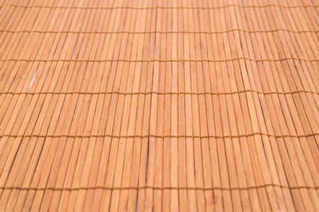 Bamboo brown straw mat as a background composition with a shallow depth of fieldの写真素材