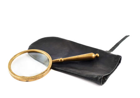 Old authentic magnifying glass over a black leather case isolated against the white backgroundの写真素材