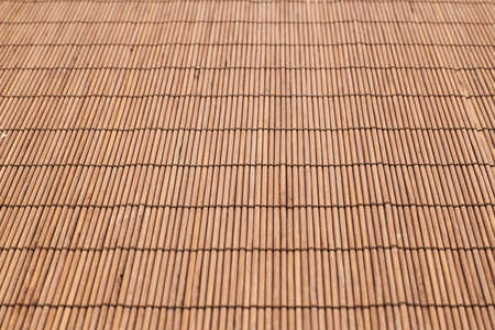 Bamboo brown straw mat as a background composition with a shallow depth of fieldの写真素材