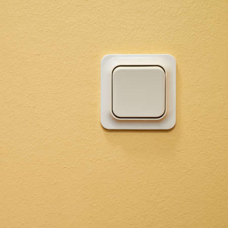 White light switch over beige painted wall as a backgroundの写真素材