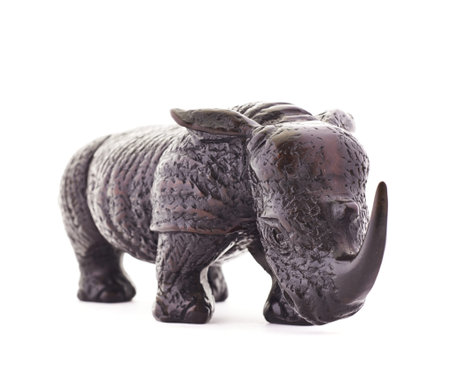 Rhinoceros rhino sculpture made of carved dark wood isolated over white backgroundの写真素材