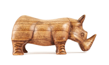 Rhinoceros rhino sculpture made of carved brown wood isolated over white backgroundの写真素材