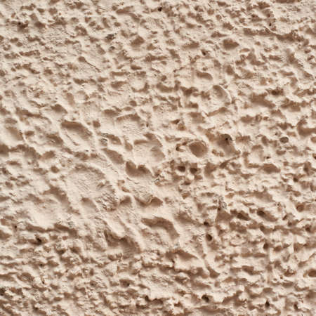 Cement covered wall painted with apricot color paint, as a background textureの写真素材
