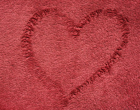 Dark red color towel cloth with a heart shape over as a texture