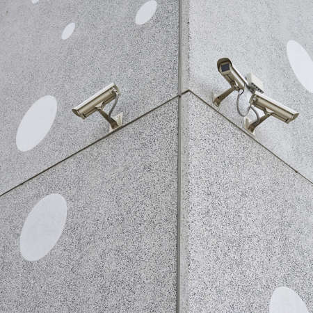 Three CCTV cameras on the concrete wall's cornerの写真素材