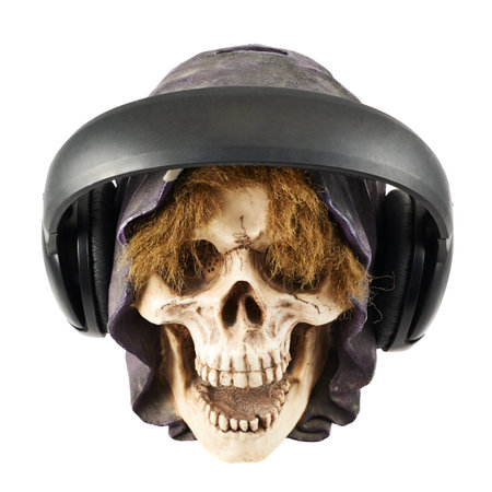 Headphones put on a ceramic skull head isolated over white backgroundの写真素材