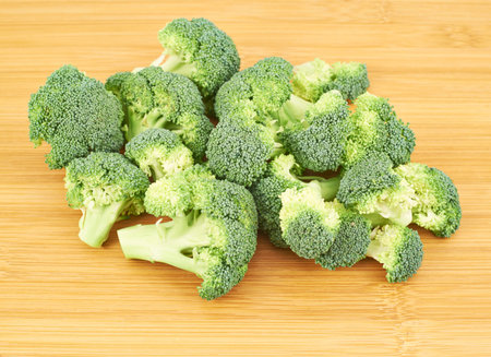 Pile of broccoli pieces over a wooden surface