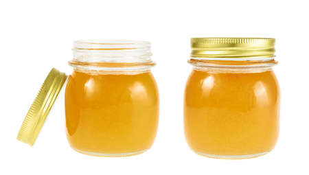 Closed and opened jar of honey isolated over the white backgroundの写真素材