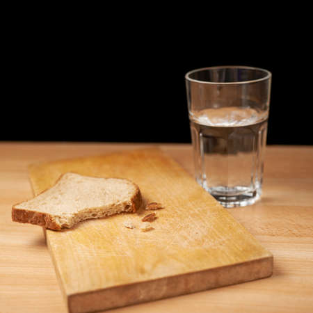 Glass of water and bread composition over the wooden surfaceの写真素材