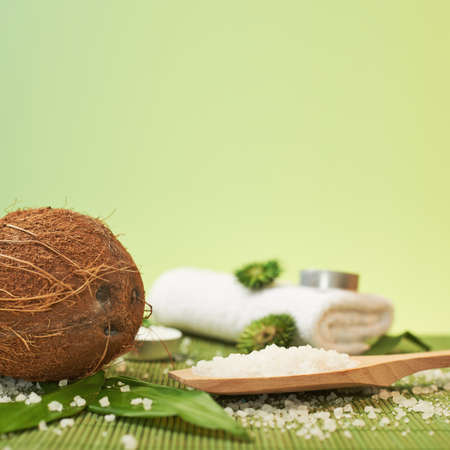 Spa bathing composition of coconut and a spoon full of aromatic salt over the bamboo matの写真素材