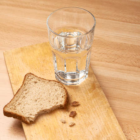 Glass of water and bread composition over the wooden surfaceの写真素材