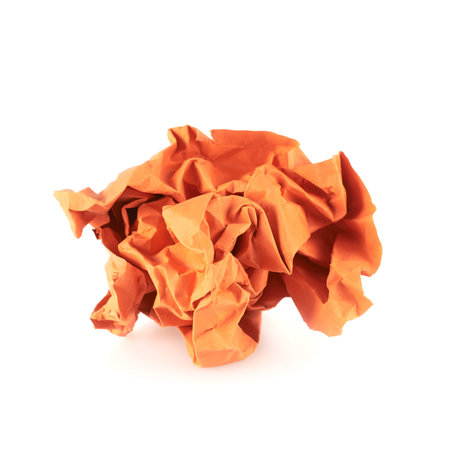 Crumpled piece of orange colored paper, isolated over the white backgroundの写真素材