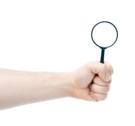 Caucasian male hand holding magnifying loupe glass, high-key light composition isolated over the white backgroundの写真素材