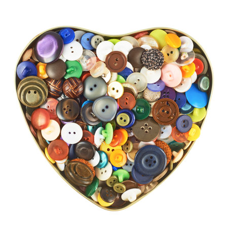 Heart shaped box filled with the multiple colorful buttons isolated over the white background