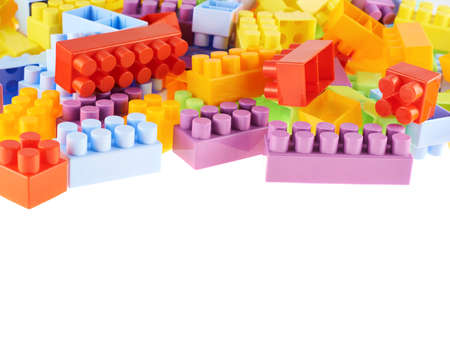 Pile of colorful plastic toy construction bricks isolated over the white as a copyspace background compostionの写真素材