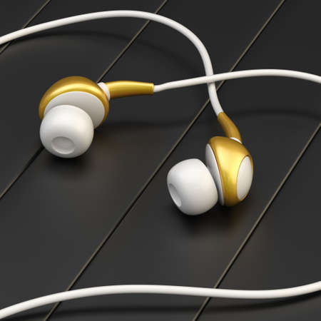 In-ear white and golden colored headphones forming a heart shape over the striped mat black surfaceの写真素材